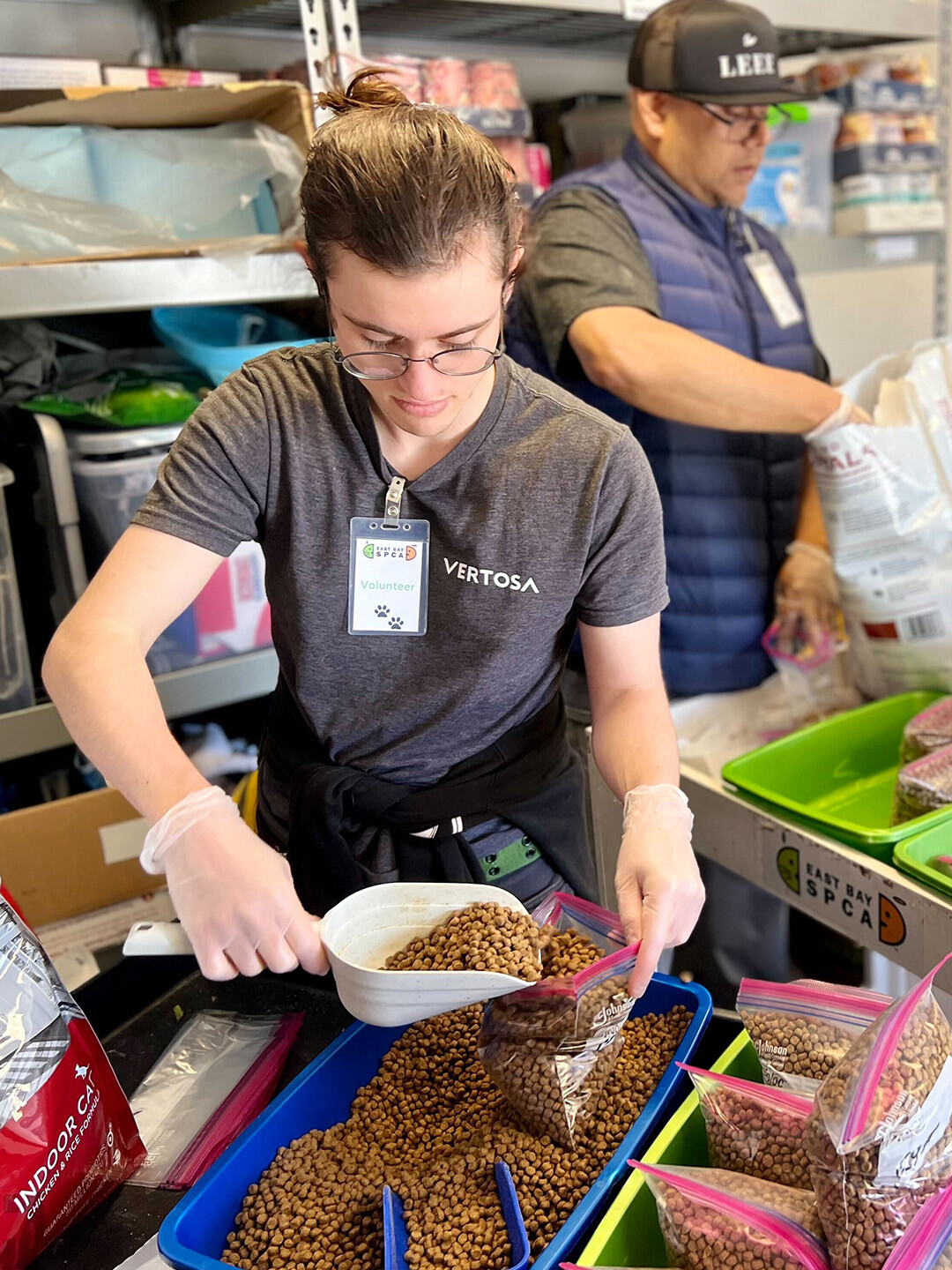 Emmet scoops dog kibble into a ziploc bag for the East Bay SPCA's food pantry