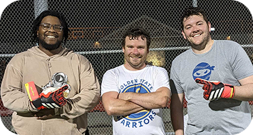 Three men smiling after a sports game.